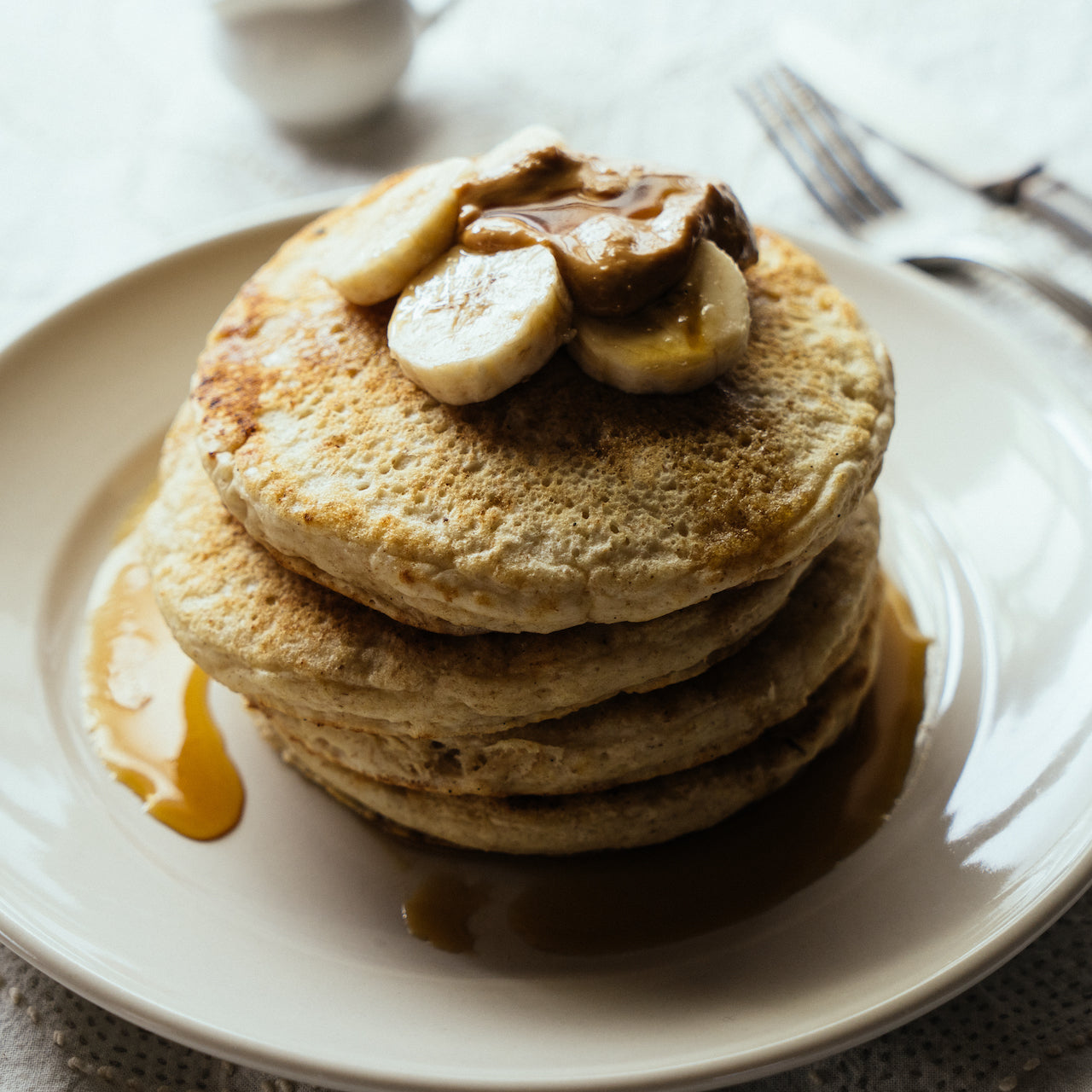 パンケーキにバナナとピーナツバターとメープルシロップをトッピング